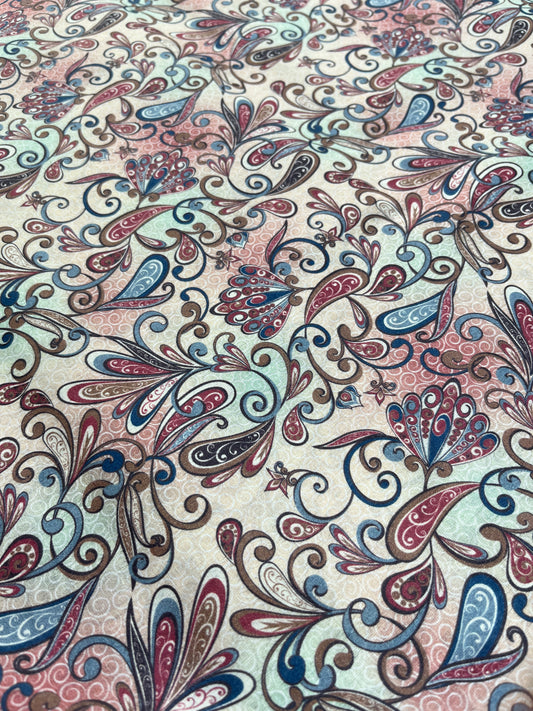 Patterned fabric with intricate designs in red, blue, and beige.