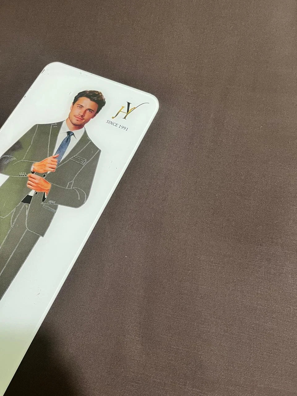 Card with a man in a suit and tie on a brown fabric