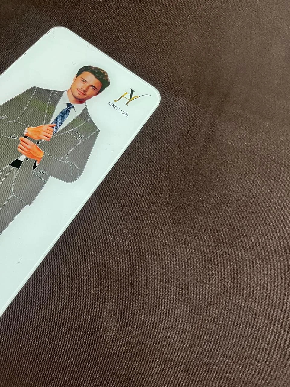 Card with a graphic of a person in a suit and tie on a brown fabric