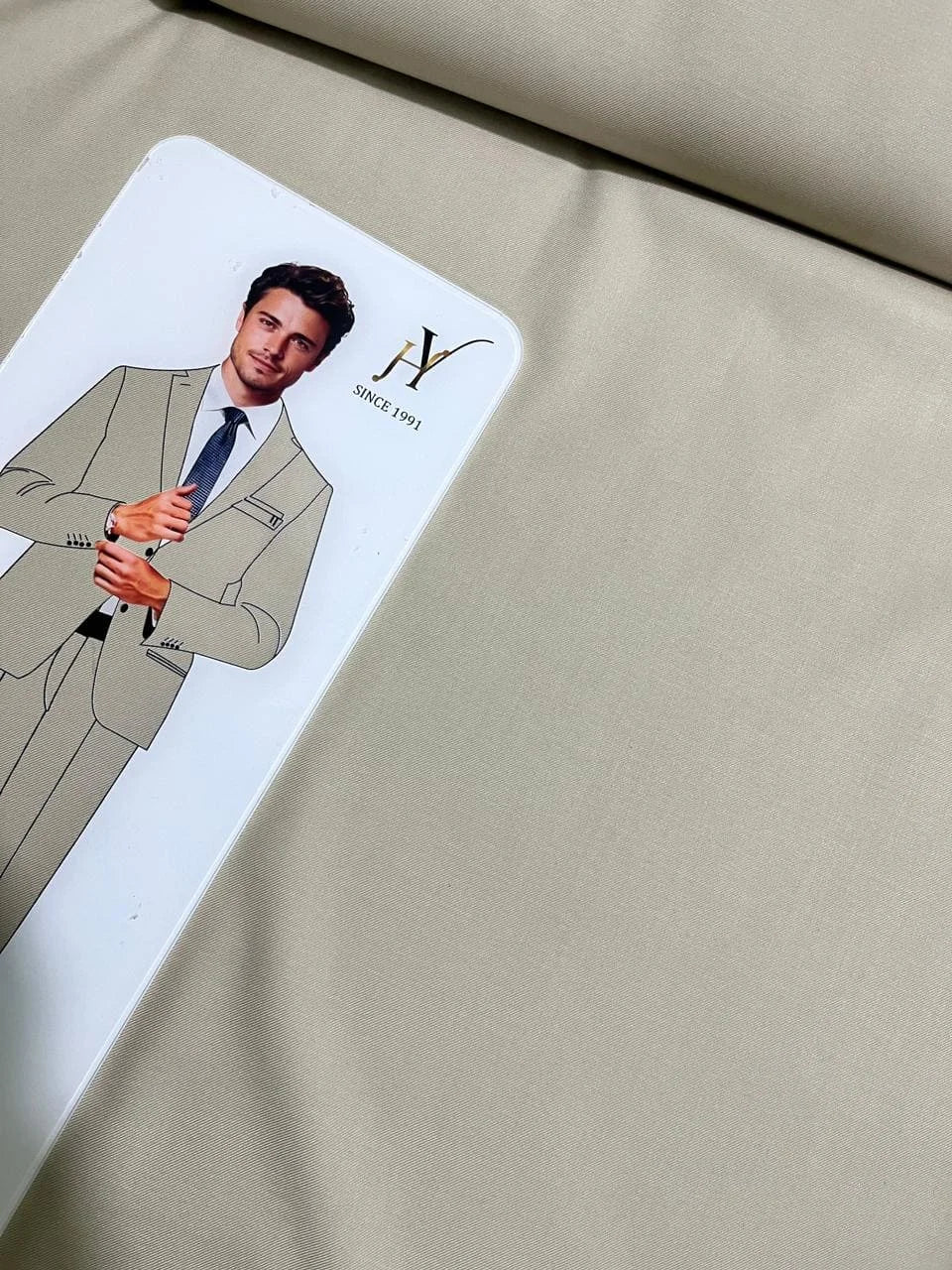 Card with a man in a suit on a beige fabric background