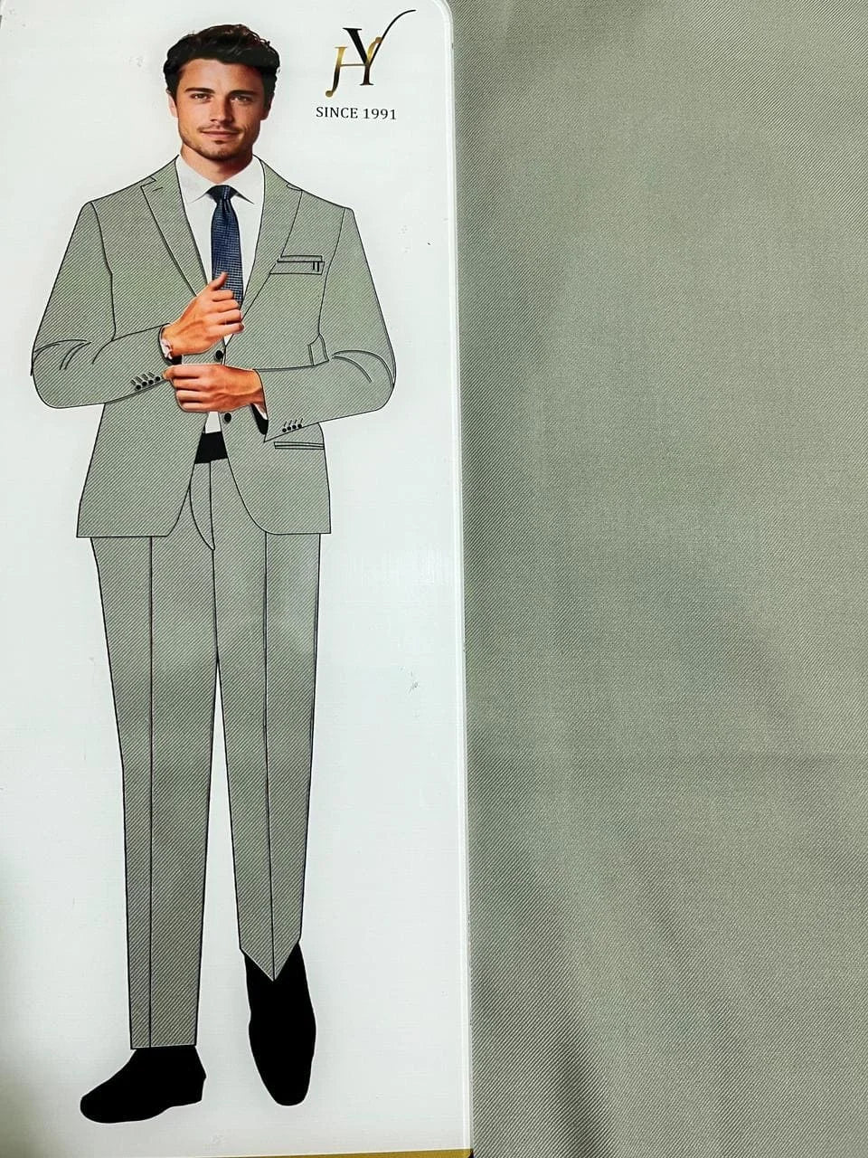 Sage green suit with a mannequin and fabric swatch on a white background