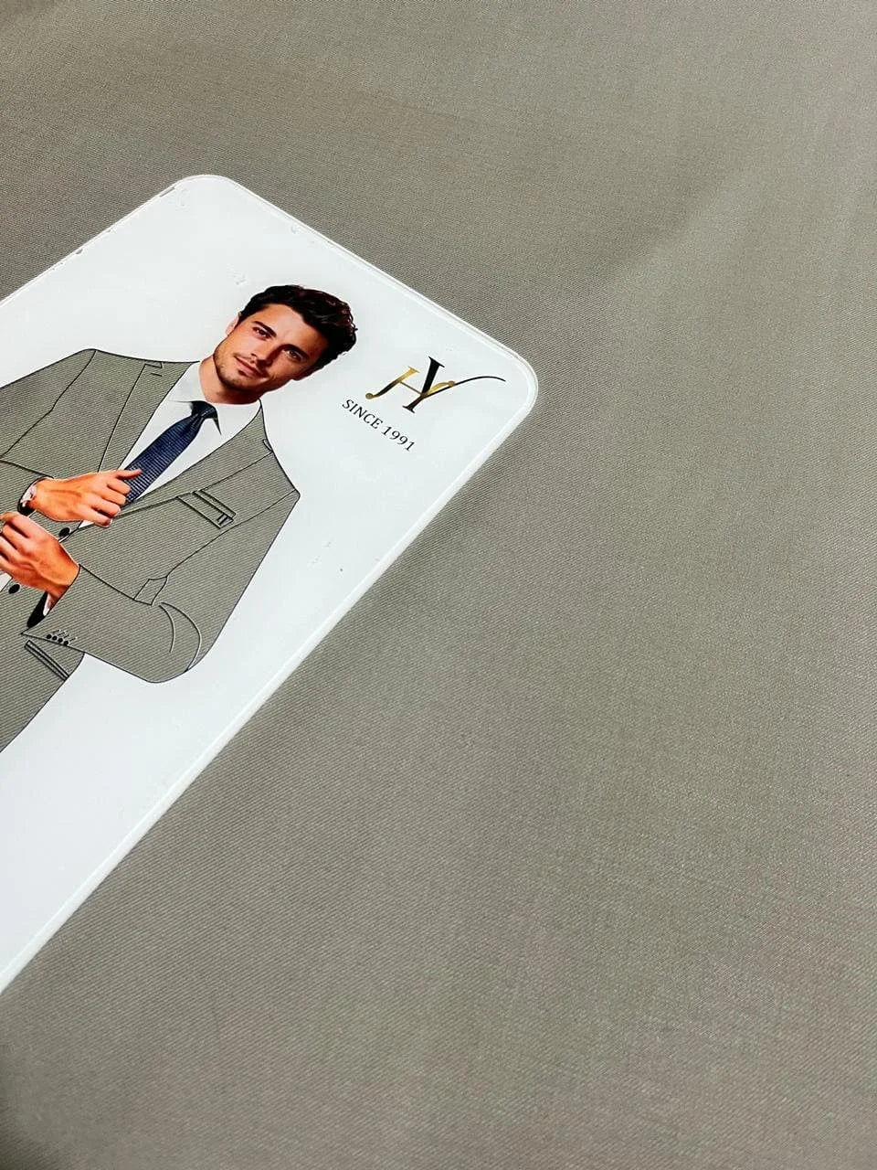 Card with a man in a suit on a taupe fabric background